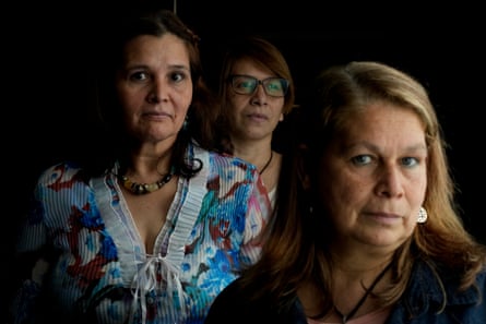 Three middle-aged Latina women pose for a portrait