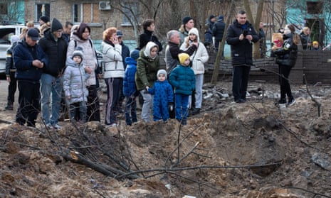 Local residents stand near a crater after a Russian attack in Kyiv, Ukraine.