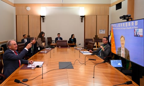 Australian trade minister, Don Farrell, (left) speaks with China’s minister of commerce, Wang Wentao, during a meeting via teleconference at parliament house on Monday.