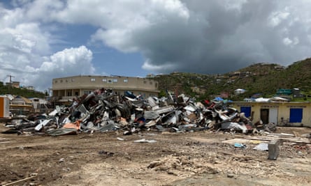 A large pile of roofing panels at the side of an empty field