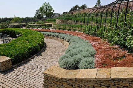 Neat, landscaped gardens with curved beds around a stone path.