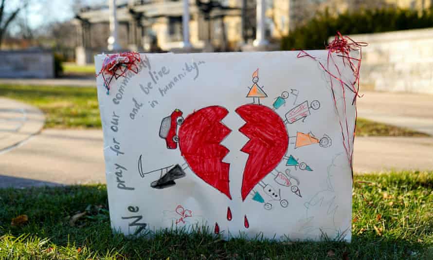 A sign is displayed at a memorial to the victims of the Waukesha Christmas parade.