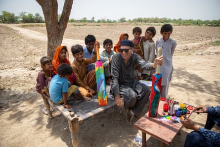 Ali Salman Anchan and Maula Dinno with local children and the cricket bats they painted.