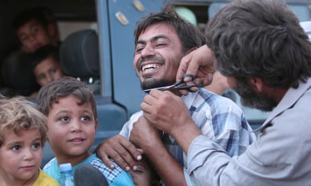 A Manbij man having his beard cut off, August 2016