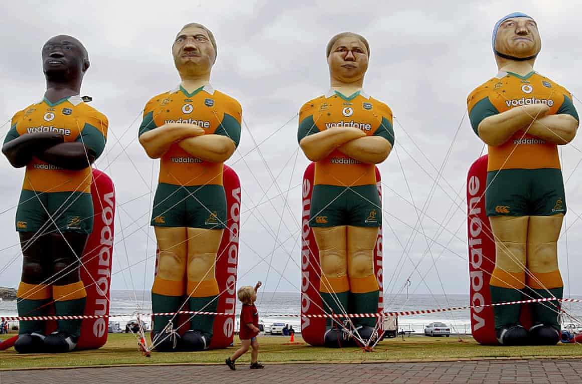 A young boy looks up at four inflatable figures of the Wallabies team on Bondi Beach in Sydney before the 2003 World Cup semi-finals