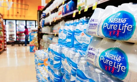 A woman walks past an aisle with bottled water at a supermarket in Los Angeles.