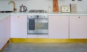 The refurbished galley kitchen in soft pink with brass fittings.