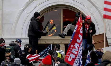 A mob climbs through a window they broke at the US Capitol during the January 6 attack.