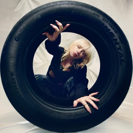 Billie Eilish looking through a tyre