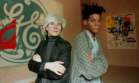 Pop artists Andy Warhol, left, and Jean-Michel Basquiat pose in front of their collaborative paintings on display at the Tony Shafrazi Gallery in New York, 1985