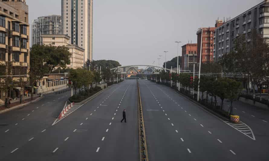 رجل يعبر طريقًا سريعًا فارغًا في 3 فبراير في ووهان بمقاطعة هوبي.