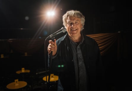 A man standing in front of a microphone, smiling
