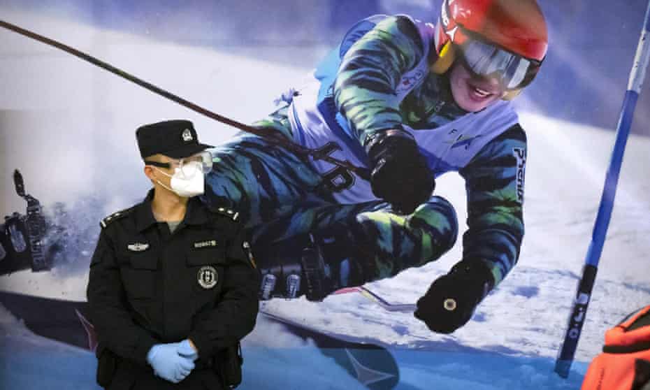 A police officer by a Winter Olympics poster in Zhangjiakou, Hebei province