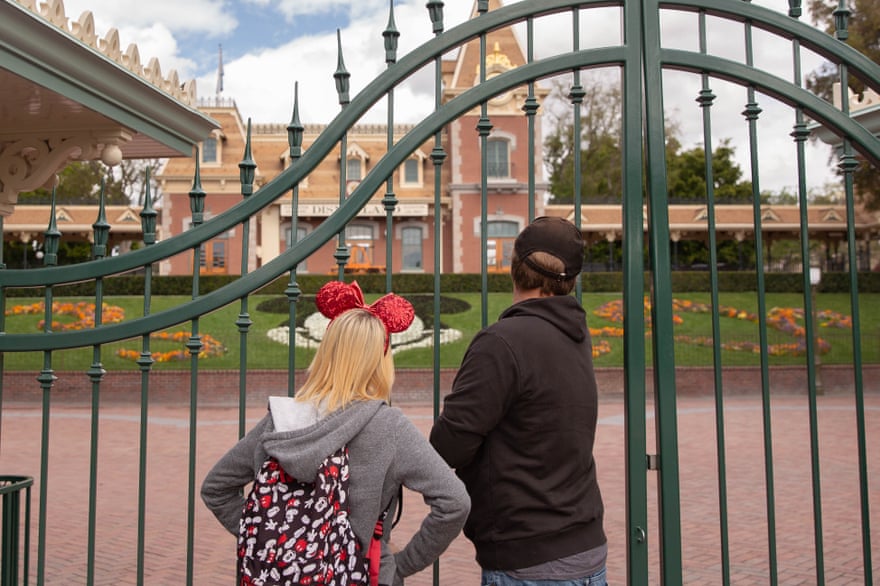 Tourists look through the fence after Disneyland was closed due to the coronavirus.