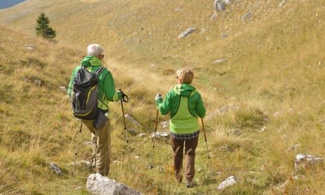 Older couple hiking on grassy hills