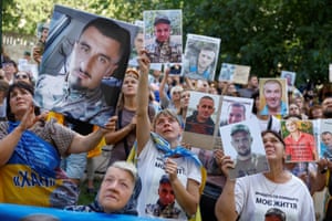 People hold portraits of their relatives