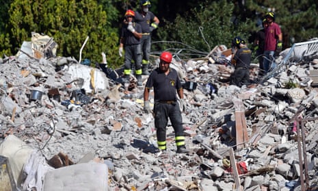 Emergency workers search the rubble of a building that was destroyed in earthquake in Amatrice