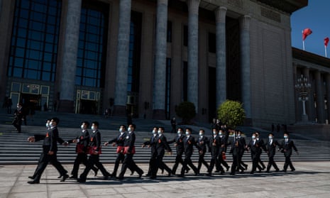 Security officers walk past the Great Hall of the People