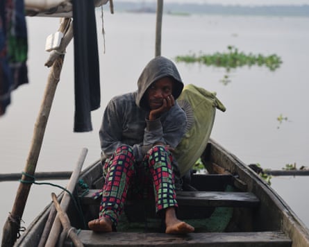 ‘The water is no longer our friend’: how dredging is pushing Lagos Lagoon towards ecosystem collapse – photo essay A man sits in a wooden boat with his head in his hands.