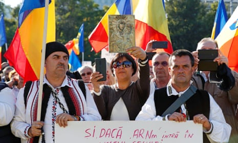 Romanians holding national flags attend a protest against new measures ordered by the government during the fourth wave of the pandemic in Bucharest.