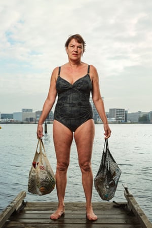 Saskia van Drimmelen holds bags of plastic waste she collected during her morning swim in the IJ River, Amsterdam, Netherlands