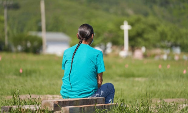 A man sits and prays at the field where the remains of over 750 children were buried on the site of the former Marieval Indian Residential School in Cowessess First Nation, Saskatchewan