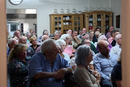 An audience of people facing the front of a room