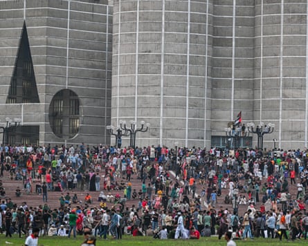 Anti-government protesters gather outside Bangladesh’s parliament celebrating the resignation of Sheikh Hasina