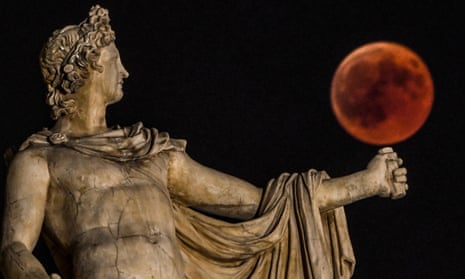 A “blood moon” eclipse beside a statue of the ancient Greek god Apollo in central Athens