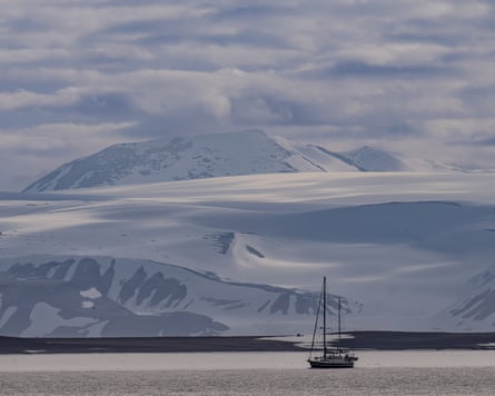 A sailboat sails past National Arctic Scientific Research Expedition near Svalbard and Jan Mayen. In the background are glaciers.