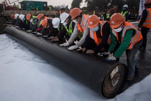Construction workers roll out damp proof lining as they build the Huoshenshan hospital in Wuhan