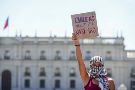 A woman holds a banner reading in Spanish: ‘Chile does not deserve this punishment,’ a pun in reference to Kast.