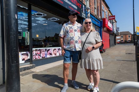 Paul and Sue Houghton stand arm in arm on a high street