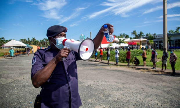 A police officer directs people queuing for Covid testing in Fiji’s capital, Suva Fiji, Coronavirus, Pacific islands, Asia pacific,No jabs, no job,harbouchanews