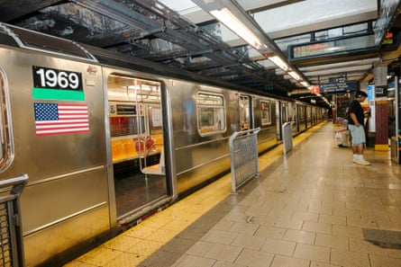 A subway platform with a car waiting with its doors open.