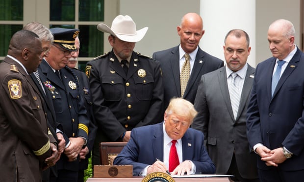 Donald Trump signs an executive order on policing in the Rose Garden of the White House on Tuesday.