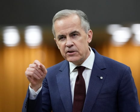 a man in a suit gestures with his right hand while speaking