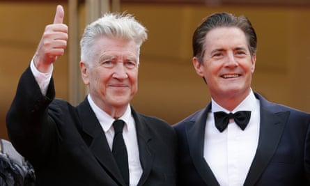 Two men in suit and ties smile side by side