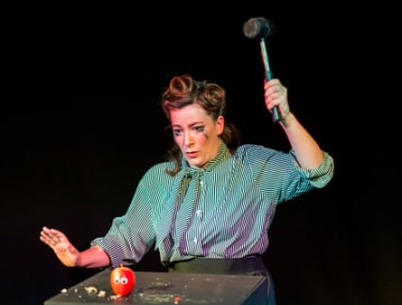 Jemma Kahn lifts a hammer over an apprehensive apple with googly eyes.