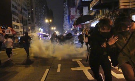 People react as police fire teargas during protests in Hong Kong