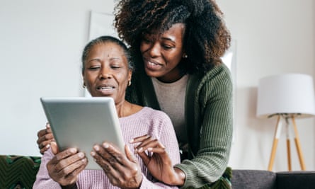 Younger woman showing older woman how to use a tablet