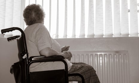 Ninety year old woman with hand on radiator looking out of window. 