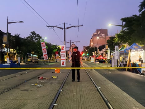 Police officers at the scene of a deadly shooting at a salsa-themed street festival in Toronto, Canada. Two people were killed, with four injured.