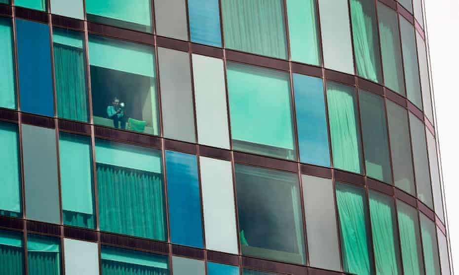 A woman looks out of the window of a Melbourne hotel on Monday where travellers returned from overseas are being held in isolation for a mandatory 14 days as the Australian government tries to contain the spread of coronavirus.