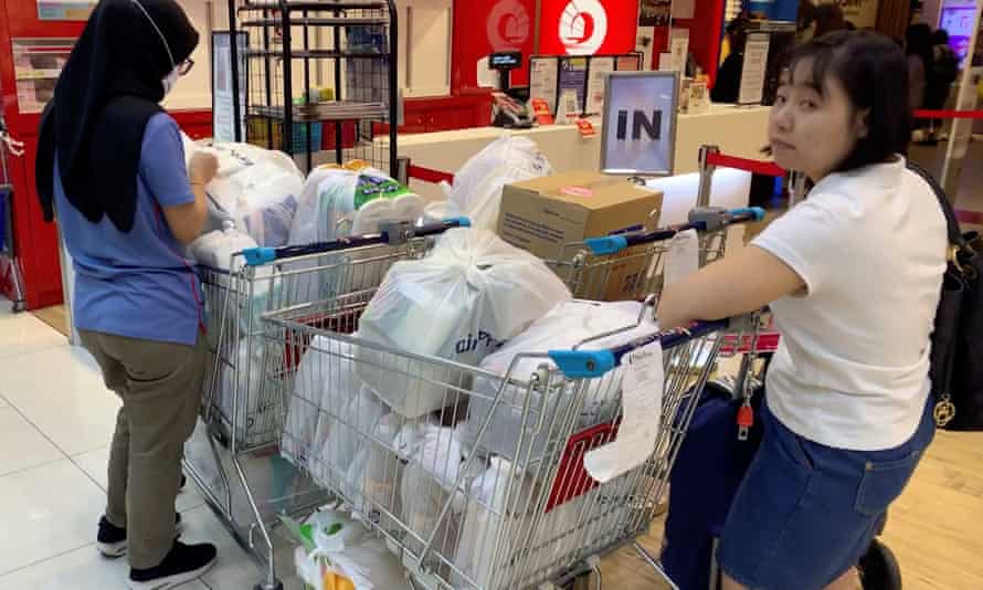 Panic buying: People fill shopping trolleys in Singapore, where the alert level has been raised to orange, its second-highest level