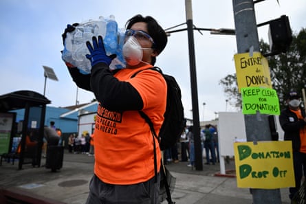 a person carries a case of water bottles
