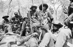 Black African soldiers holding AK-47 assault rifles