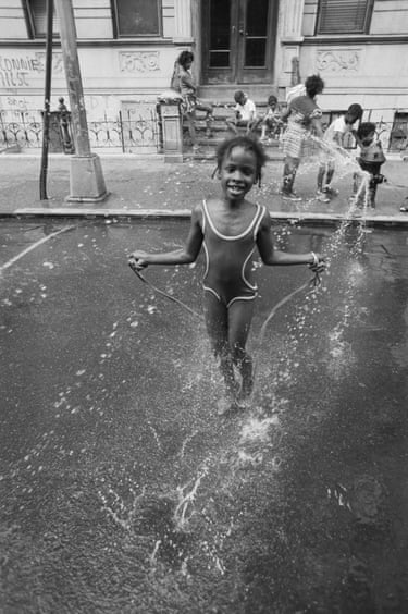 A girl plays in water spraying out of a fire hydrant