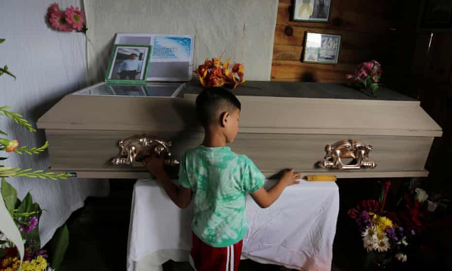 A child touches the coffin of Nelson Espinal, who was shot dead outside his home on 18 December 2018 in Tegucigalpa, Honduras. 