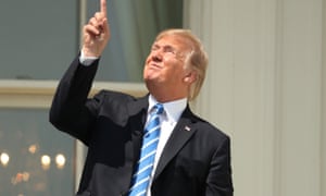President Donald Trump points to the sun during the solar eclipse, Monday, Aug. 21, 2017, at the White House in Washington.